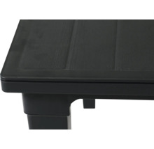 Vue rapprochée du coin d une table en plastique noir avec une surface texturée aspect bois.