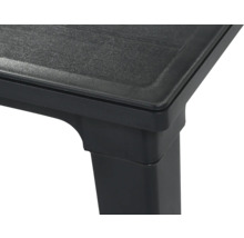 Gros plan d'un coin de table en plastique noir avec une surface texturée et un pied carré.