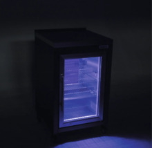 Petit réfrigérateur à boissons avec porte vitrée, éclairage intérieur bleu et clayettes métalliques.