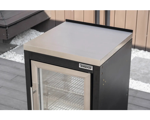 Module de réfrigérateur d'extérieur Tenneker avec plan de travail en acier inoxydable et porte vitrée dans une cuisine d'été lumineuse.