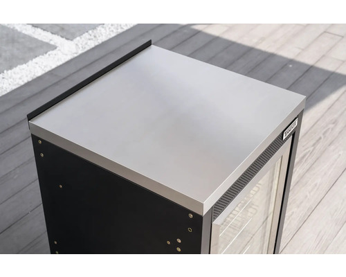Module de cuisine extérieure Tenneker avec plan de travail en acier inoxydable, porte vitrée et Tenneker Logo sur une terrasse en bois.