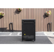 Meuble bas de cuisine d'extérieur mobile noir avec fentes d'aération et raccordement électrique sur une terrasse devant une clôture en bois.