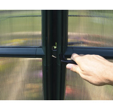 Hand am Türgriff eines Gewächshauses mit Hohlkammerplatten.