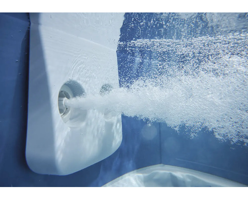 Vue sous-marine d'une buse de massage de piscine projetant un jet puissant de bulles d'air.