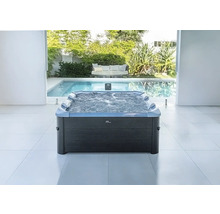 Spa gonflable MSpa rectangulaire avec fonction bulles et repose-têtes dans une pièce lumineuse avec vue sur piscine et jardin.