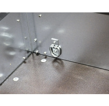 Anneau d'arrimage en métal sur une paroi latérale de remorque pour sécuriser le chargement au-dessus d'un sol structuré.