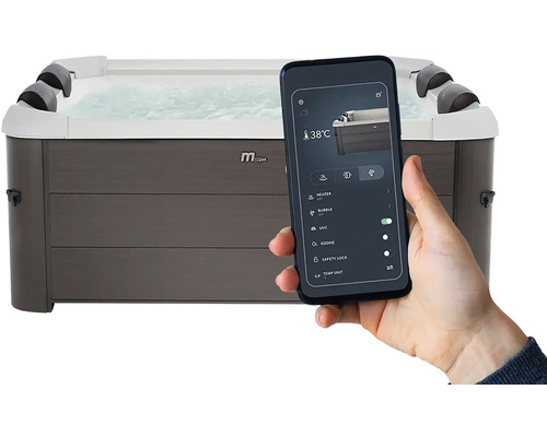 Main tenant un smartphone avec une application pour piloter un spa rectangulaire aspect bois gris, affichant des réglages tels que 38 degrés.