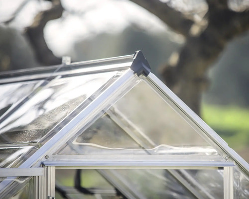 Nahaufnahme des Giebels eines Gewächshauses mit Aluminiumprofilen und transparenten Paneelen.