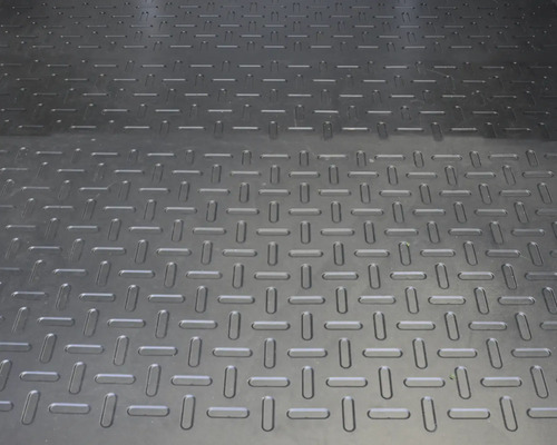 Tapis en caoutchouc noir antidérapant avec structure en tôle larmée.