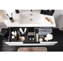 Moderner wäissen Waschtisch mat opener Schublad, Schubladen-Organisatiounssystem mat Toilettenartikelen an hellbrong Badematte.
