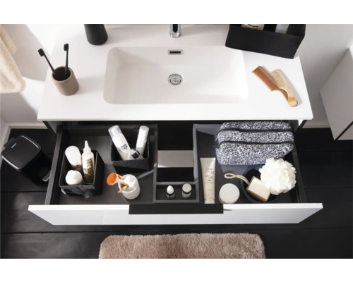 Moderner wäissen Waschtisch mat opener Schublad, Schubladen-Organisatiounssystem mat Toilettenartikelen an hellbrong Badematte.