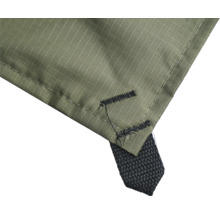 Vue de détail d'une bâche de protection verte en tissu avec un coin renforcé et une boucle de fixation noire.