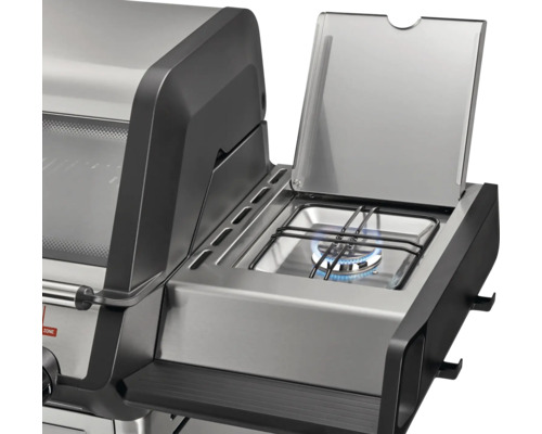 Gaskocher eines Gasgrills mit Flamme und aufgeklapptem Deckel aus Edelstahl.