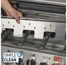 Eine Hand entnimmt eine Flammenabdeckung aus Edelstahl aus einem Gasgrill zur Reinigung, die Brennerrohre und das Simple Clean System sind sichtbar.