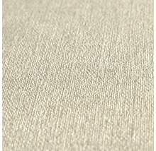 Gros plan d'un papier peint intissé beige avec une surface à structure fine et granuleuse.