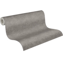 Papier peint intissé avec une texture fine en gris, rouleau partiellement déroulé.