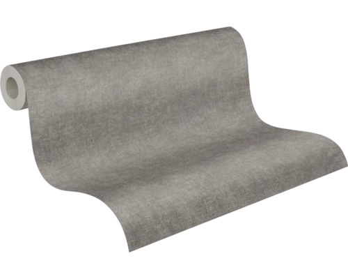 Papier peint intissé avec une texture fine en gris, rouleau partiellement déroulé.
