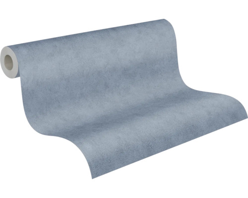 Papier peint intissé bleu avec surface structurée aspect béton, légèrement déroulé.
