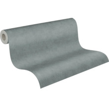 Papier peint intissé aspect béton, texturé, gris, partiellement déroulé.
