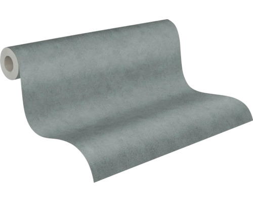 Papier peint intissé aspect béton, texturé, gris, partiellement déroulé.