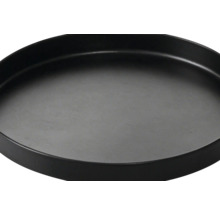 Dessous de plat rond noir avec bord surélevé.