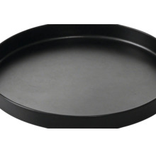 Soucoupe noire ronde avec un rebord surélevé.