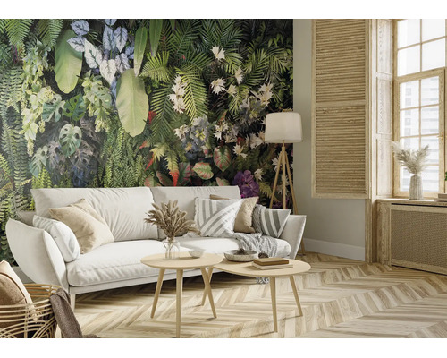 Salon avec papier peint panoramique motif jungle, canapé blanc et mobilier en bois. Pièce lumineuse et organisée avec parquet.