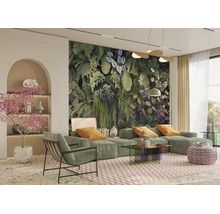 Salon moderne avec un grand papier peint tropical, canapé modulaire vert, fauteuil, table en verre et décoration botanique.