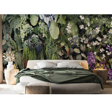 Papier peint photo avec motif de jungle tropicale dans une chambre avec un lit moderne et des tables de chevet en bois.