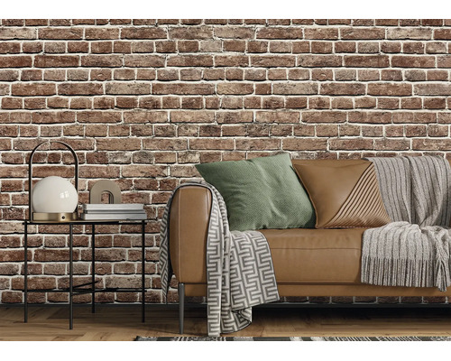 Papier peint intissé aspect brique dans un salon de style industriel avec canapé, table d'appoint et textiles.