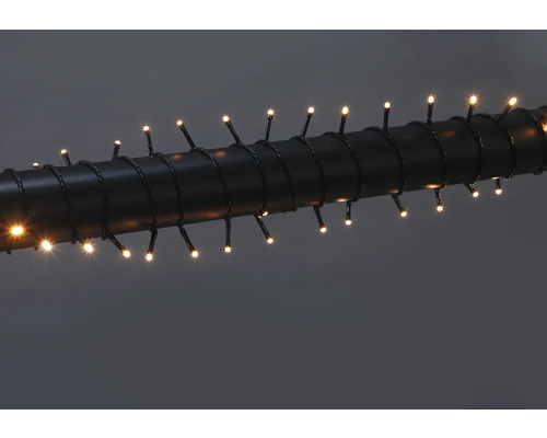 LED-Lichterkette mit warmweißen Dioden, um ein dunkles Rohr gewickelt.