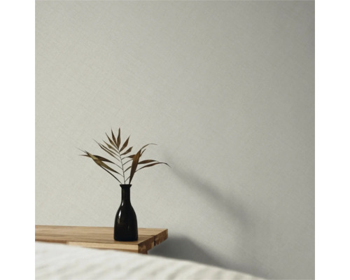Papier peint intissé avec structure en lin fine dans une pièce minimaliste avec table en bois et vase.