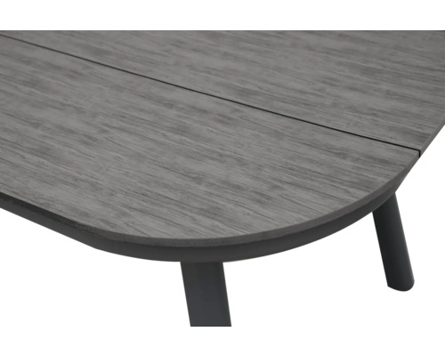 Vue rapprochée d'un plateau de table avec structure en bois et angle arrondi sur un piètement métallique sombre.