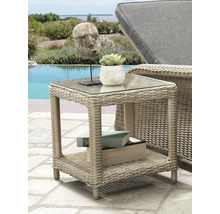 Table d appoint carree en polyrotin avec plateau en verre et etagere sur une terrasse lumineuse au bord de la piscine pres d une chaise longue.
