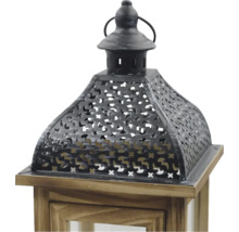Partie supérieure d'une lanterne en bois brun et métal noir avec motif ajouré décoratif et poignée.