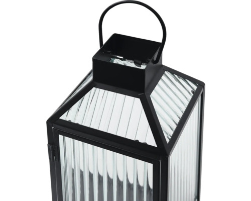 Schwarze Metalllaterne mit geriffeltem Glas und Tragegriff.