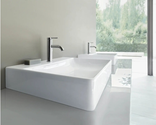 Zwei weiße rechteckige Aufsatzwaschbecken aus Keramik mit verchromten Armaturen in einem hellen, modernen Badezimmer.