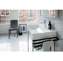 Helles, modernes Badezimmer mit rechteckigem Aufsatzwaschbecken aus weißer Keramik auf einem schwarzen Metallgestell mit Handtuchhalter.