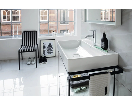 Helles, modernes Badezimmer mit rechteckigem Aufsatzwaschbecken aus weißer Keramik auf einem schwarzen Metallgestell mit Handtuchhalter.