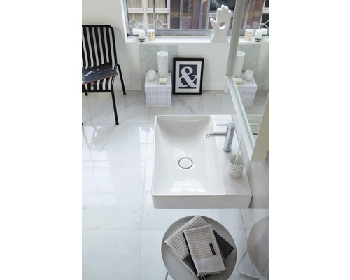 Modernes helles Badezimmer mit weißem rechteckigem Waschtisch, verchromter Armatur, großen Fliesen in Marmoroptik und schwarz-weißer Dekoration.