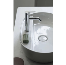 Moderner weißer Aufsatzwaschtisch mit verchromter Einhebel-Waschtischarmatur und einem Stück Seife auf der Ablage.