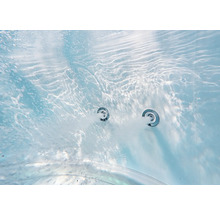 Vue sous-marine rapprochée de deux buses de massage actives avec de l'eau bouillonnante dans une piscine ou une baignoire.