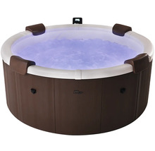 Jacuzzi rond aspect bois avec bord blanc, quatre appuie-tête, eau bouillonnante éclairée en bleu et logo MSpa.