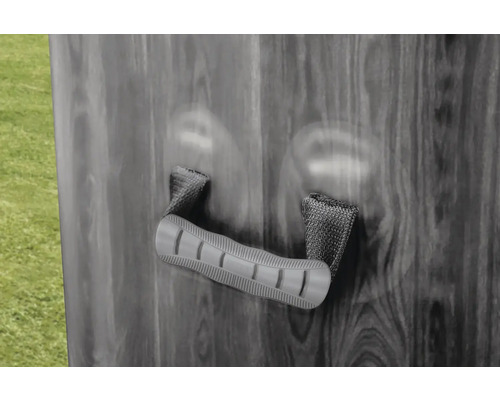 Poignée de transport avec boucles tissées sur une paroi aspect bois.