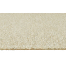 Gros plan d'une moquette de couleur crème avec poil coupé doux et envers visible.