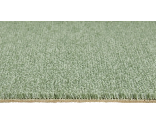 Gros plan d'une moquette verte douce à poils denses avec envers visible.