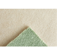 Moquette verte avec surface texturée et envers en feutre beige. Vue détaillée de la structure du matériau.