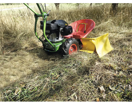Motofaucheuse Agria avec siège rouge et capot de protection jaune en action dans une prairie lumineuse avec de hautes herbes sèches.