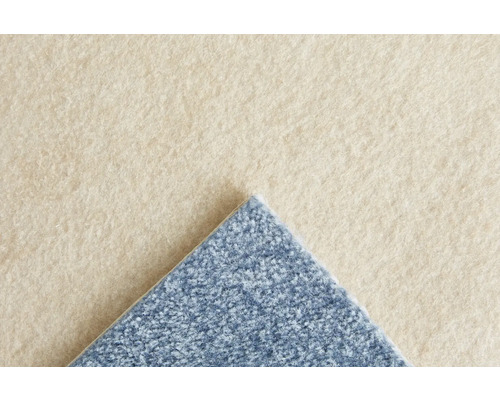 Gros plan d'une moquette beige et bleue avec une surface douce, texturée et des poils visibles.
