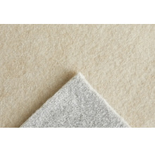 Gros plan sur un tapis avec une surface beige et un envers gris.